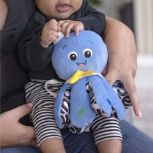 Blue octopus plush toy held by a baby, yellow bow and stitched leaf detail