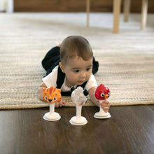 Three animal jingle rattles on rug: orange tiger, red bird, black-and-white zebra on stems