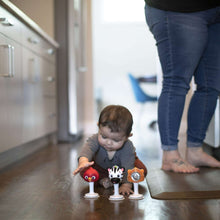 Animal jingle rattles on floor: red bird, black-and-white zebra, orange tiger with white bases