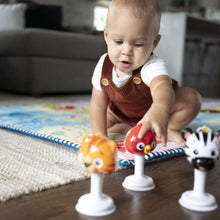 Three animal jingle rattles on white bases: orange tiger, red bird, black-and-white zebra