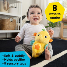 Yellow seahorse plush soother held by a smiling baby, teal fins and orange star