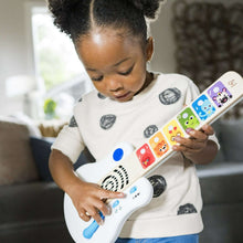 Baby playing toy guitar, white body with blue control knob and colorful animal keys