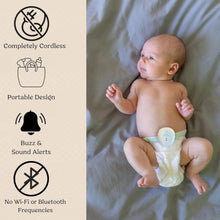 Baby wearing a diaper sensor device on a white fabric surface
