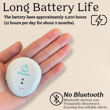 Baby motion breathing sensor with white clip-style device in a hand