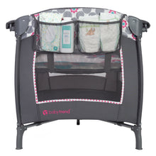 Gray baby playard with mesh organizer pockets and floral polka-dot border