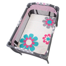 Flower-pattern bassinet mattress insert on a gray baby playard