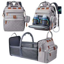 Grey diaper backpack with fold-open travel bassinet, insulated pockets, and changing pad.