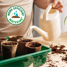 Watering seedling trays with a watering can filled from seed starting mix