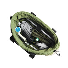 Open tote bag with green lining and interior pockets for toiletries and cards.