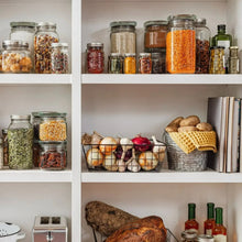 Assorted mason jars for pantry storage, filled jars on open shelving