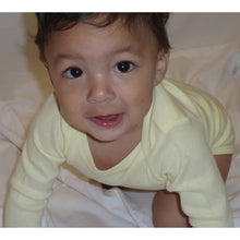 Newborn baby in pale yellow bodysuit and light gray bib