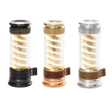 Three glowing Edison light sticks in clear tubes with black, gold, and silver bases.