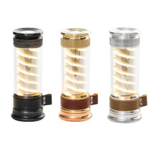 Three Edison light sticks with warm amber glow in black, brass, and clear housings