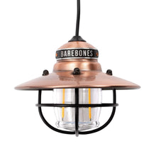 Copper Edison pendant light with glass globe and black protective cage.