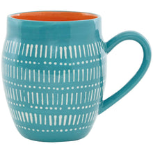 Teal ceramic mug with white dotted stripe pattern and orange interior.