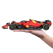 Red and black Formula race car model, side view with wheels and sponsor decals, held