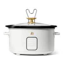 White slow cooker with black lid, gold knob, and touch control display at the front