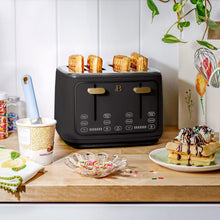 Black four-slice toaster with toast in its slots and touch controls