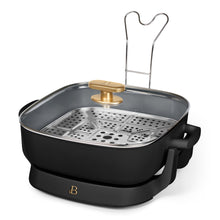 Black electric skillet with glass lid, gold knob, and perforated steaming insert