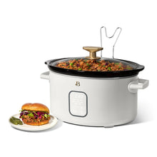 White programmable slow cooker with open lid and food inside
