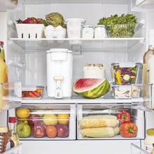 Beautiful by PUR white water filter dispenser stored on a refrigerator shelf