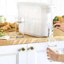 Beautiful by PUR white water filter dispenser with water pouring from its spigot