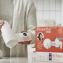 Beautiful by PUR faucet filter system being held beside its retail box