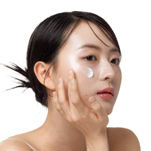 Moisturizing cream on face, white dots on cheeks