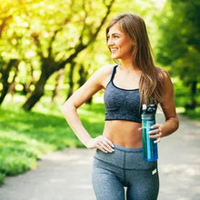Fiber supplement bottle held by a woman in sportswear outdoors
