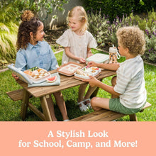 Kids meal set with lunch trays and a water bottle on a picnic table