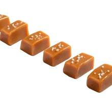 Salt-topped caramel cubes, golden-brown candies with white flakes