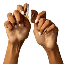 Caramel-filled chocolate cup pieces held between two hands