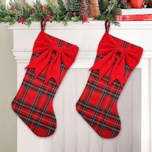 Two red plaid Christmas stockings with large red bows and loops