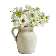 Artificial wildflower arrangement in beige ceramic jug vase with white and green flowers