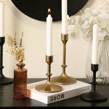 Gold cast iron taper candle holder with round base and slim stem
