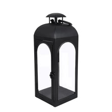 Black metal lantern candle holder with curved top handle and front glass panels