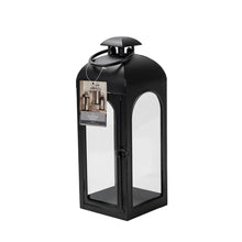 Black metal lantern candle holder with product label on front glass panel