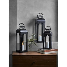 Black metal lantern candle holder with arched window panels and top handle