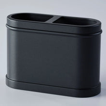Black metal toothbrush holder with two top openings for toothbrushes