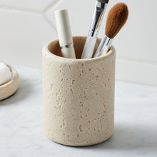 Speckled beige faux stone toothbrush holder holding multiple toothbrush heads