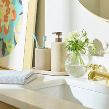 Speckled beige faux stone toothbrush holders on a bathroom countertop