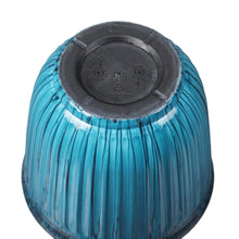 Underside of light blue ribbed resin planter with dark circular base and drainage insert