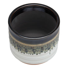 Round ceramic plant planter with dark top and speckled drip pattern over white