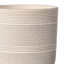 Close-up of round ceramic planter with stacked horizontal rings and textured sides