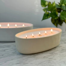 Beige ceramic 5-wick candle with five lit wicks