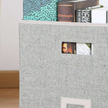 Gray fabric cube storage bin with front pocket detail and label patch