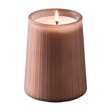 Pink ribbed jar candle with white wax and lit wick