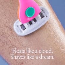 Pink razor gliding over shaving foam on skin