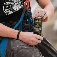 Espresso coffee with cream can by Black Rifle Coffee Company held in hand.