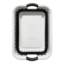 Collapsible laundry basket in compact folded form, white frame with gray handles